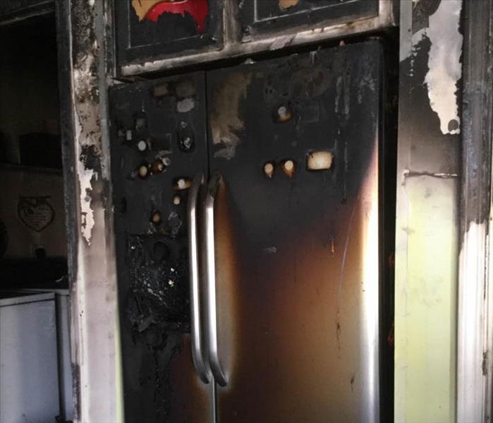 Kitchen fire damage with soot on fridge